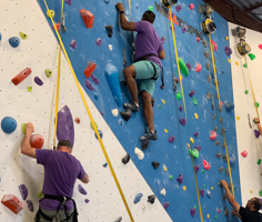 coworkers at a company event wall climbing
